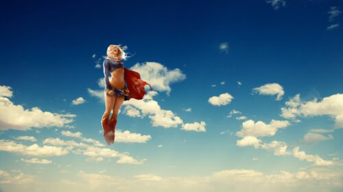 Stunning Supergirl Flying Above Metropolis Cityscape 4K Desktop Wallpaper