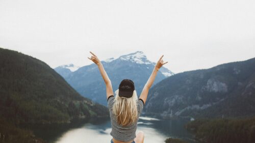 Blonde Girl Celebrating at Mountain Lake View 4K Desktop Wallpaper