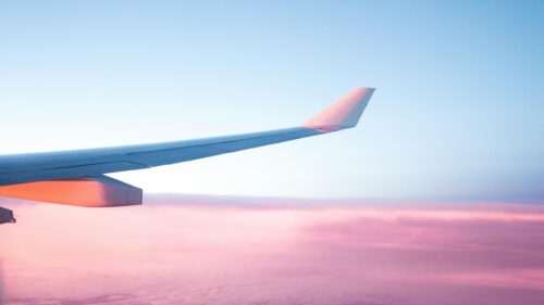 Airplane Wing Above Pink Sunset Clouds 4K Desktop Wallpaper