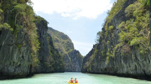 Kayaking Through Tropical Limestone Cliffs Lagoon 4K Desktop Wallpaper