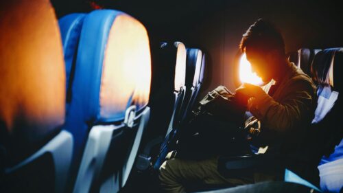 Solitary Traveler Looking Through Backpack on Plane Flight 4K Wallpaper