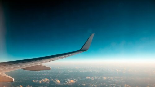 Airplane Wing Soaring Above Clouds At Sunset 4K Desktop Wallpaper