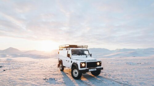 White Land Rover Defender in Snowy Arctic Landscape 4K Wallpaper