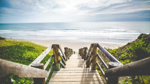 Wooden Stairway Down to a Sandy Beach Ocean View 4K Desktop Wallpaper