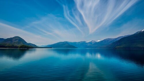 Stunning Alaskan Fjord with Reflective Blue Waters and Cirrus Clouds 4K Wallpaper