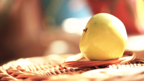 Macro Shot of a Fresh Green Apple on Woven Texture Desktop Wallpaper