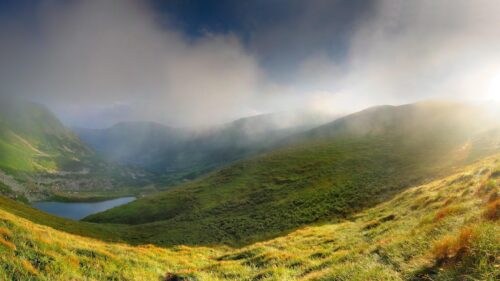 Breathtaking Mountain Valley with Foggy Peaks and Golden Sunlight PC Wallpaper