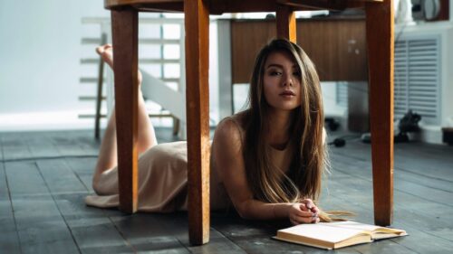 Beautiful Young Woman Reading a Book Under a Table PC Wallpaper