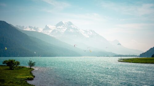 Breathtaking Kitesurfing on Alpine Lake with Snowy Mountain Peaks Desktop Wallpaper