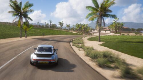 Classic Silver Porsche 911 Turbo Driving on Tropical Coastal Road 4K Wallpaper