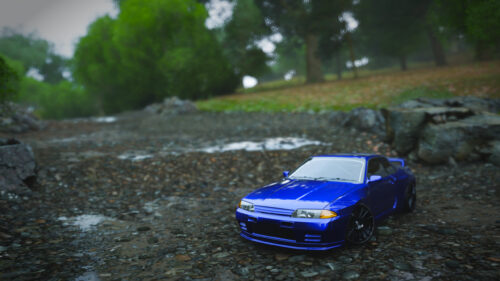 Stunning Blue Nissan Skyline R32 GTR Parked on a Rainy Rocky Path PC Wallpaper
