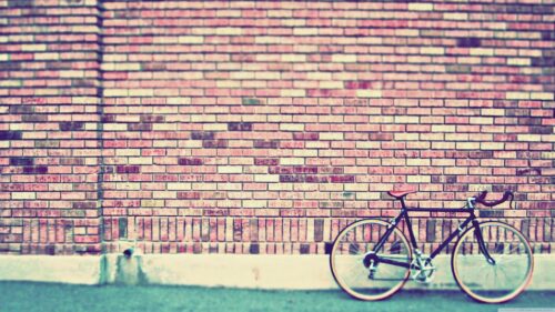 Vintage Bicycle Against a Rustic Red Brick Wall Desktop Wallpaper