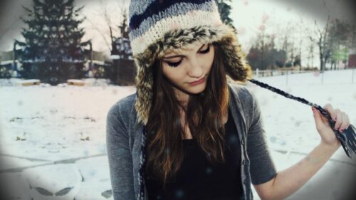 Beautiful Girl in Winter Hat Surrounded by Snowflakes 4K Wallpaper