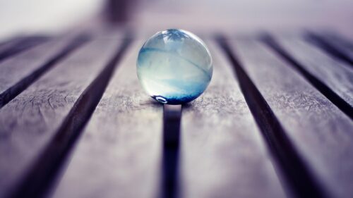 Abstract Glass Marble Reflection on Dark Wooden Slats Desktop Wallpaper