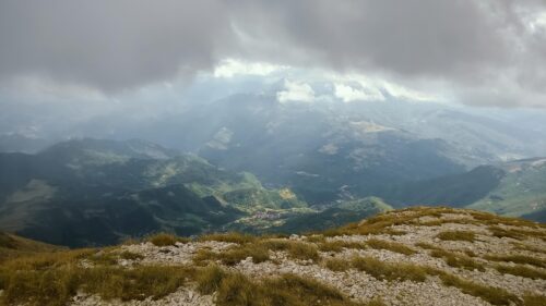 Dramatic Mountain Valley View Under Stormy Clouds PC Wallpaper