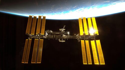 International Space Station Orbiting Earth Glowing Solar Panels PC Wallpaper