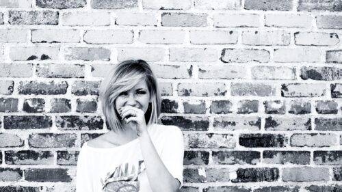 Stunning Black and White Portrait of a Woman Against a Brick Wall PC Wallpaper