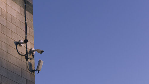 Minimalist Security Camera on Brick Wall Against Blue Sky PC Wallpaper