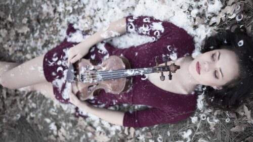 Dreamy Woman Holding Vintage Violin Surrounded by White Feathers Desktop Wallpaper