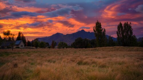 Fiery Sunset Over Mountainous Meadow Landscape PC Wallpaper