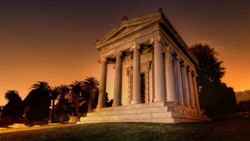 Ancient Greek Revival Mausoleum Under Amber Night Sky Desktop Wallpaper