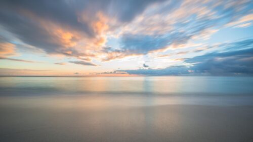 Serene Tropical Beach Sunset with Long Exposure Clouds 4K Wallpaper