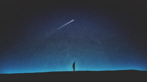 Silhouette Man Reaching for Shooting Star in Night Sky 4K Desktop Wallpaper