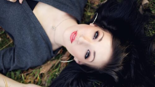 Beautiful Young Woman With Black Hair Lying on Grass Desktop Wallpaper