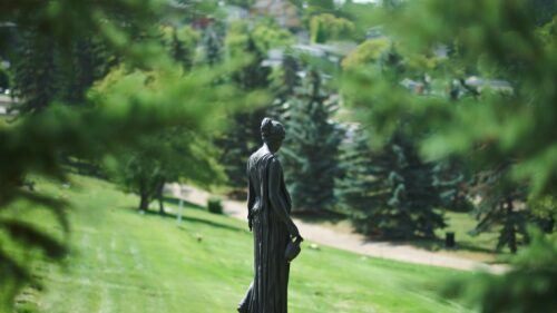Elegant Bronze Woman Statue in Lush Green Park Desktop Wallpaper