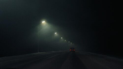 Lonely Car Driving on Dark Foggy Snowy Road 4K Wallpaper
