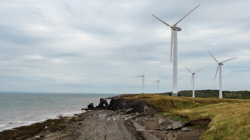 Scenic Coastal Wind Farm Landscape with Rugged Shoreline PC Wallpaper