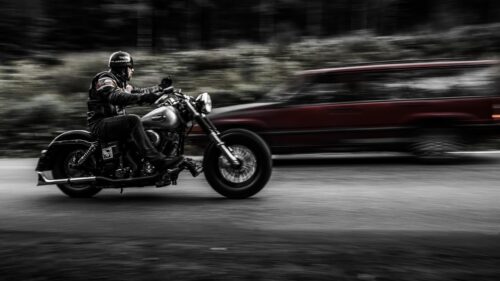 Biker Riding Cruiser Motorcycle on Road High Speed 4K Wallpaper