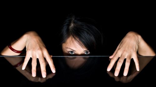 Mysterious Woman Peeking Over Dark Surface High Resolution 4K Wallpaper