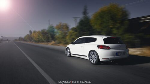 White Volkswagen Scirocco Driving on Open Road PC Wallpaper