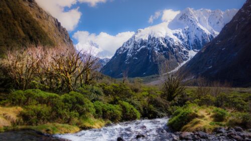 Majestic Snow Capped Mountain Peaks and Flowing River Valley 4K Wallpaper