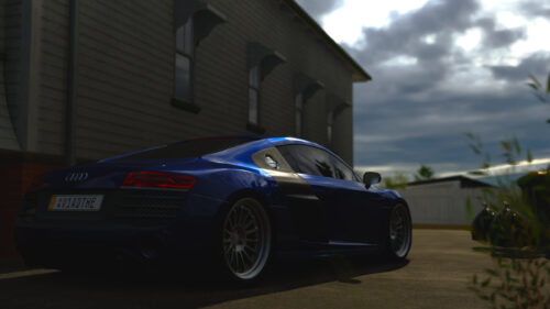 Stunning Blue Audi R8 Sportscar Parked Beside Antique Building Desktop Wallpaper
