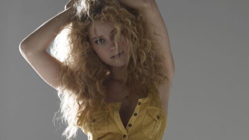 Stunning Blonde Woman with Curly Hair in Yellow Top PC Wallpaper