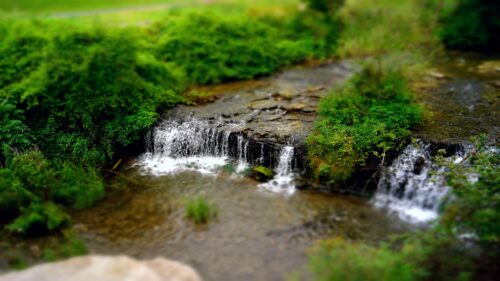 Miniature Tilt Shift Waterfall in Lush Green Forest 4K Wallpaper