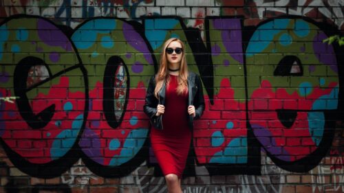 Stylish Woman in Red Dress Against Graffiti Brick Wall 4K Wallpaper