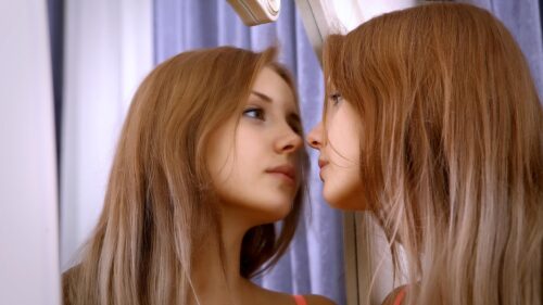 Beautiful Young Woman Gazing Into Mirror Reflection Desktop Wallpaper