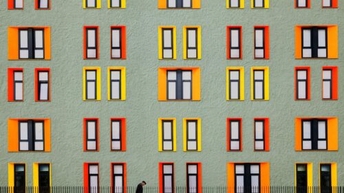 Minimalist Architectural Building Facade with Vibrant Orange and Yellow Frames PC Wallpaper