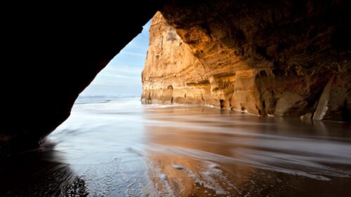 Breathtaking Coastal Sea Cave with Golden Light Desktop Wallpaper