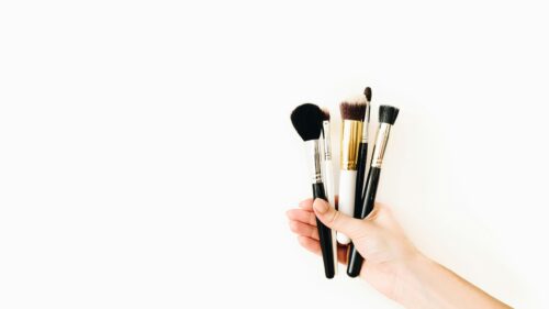 Minimalist Makeup Brushes Held in Hand High Resolution Desktop Wallpaper