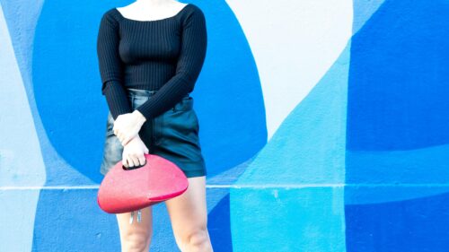 Modern Fashion Chic Woman with Red Handbag Against Blue Mural Desktop Wallpaper