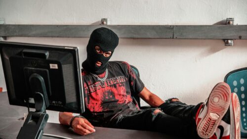 Edgy Hacker in Balaclava and Disturbed T-Shirt 4K Desktop Wallpaper
