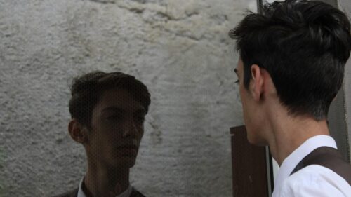 Young Man Looking at Reflection in Mirror 4K Desktop Wallpaper