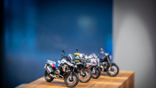 Collection of BMW Motorcycle Scale Models on Wooden Table 4K Wallpaper