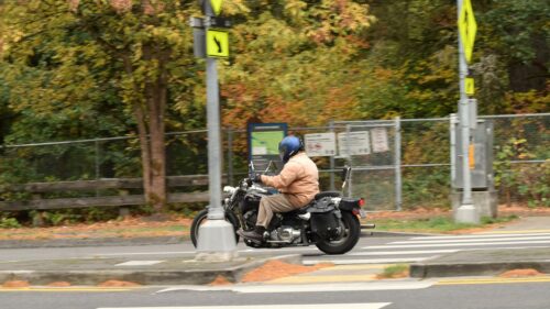 Rider on a Cruiser Motorcycle Crossing the Road 4K Wallpaper