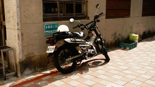 Tan Honda CT125 Trail Bike Parked on Cobblestone Street 4K Wallpaper