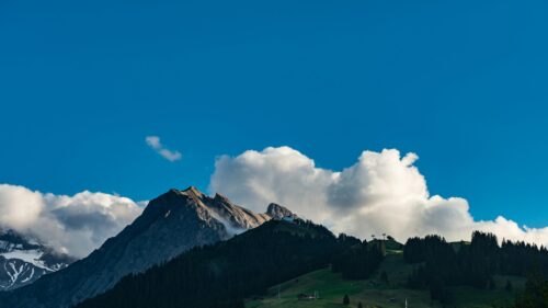 Majestic Alpine Mountain Peak Under Fluffy Clouds 4K Wallpaper